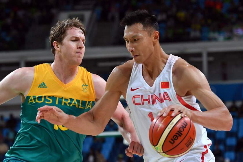 China's Yi Jianlian, right, works around Australia's forward Cameron Bairstow at the Olympics on Tuesday.