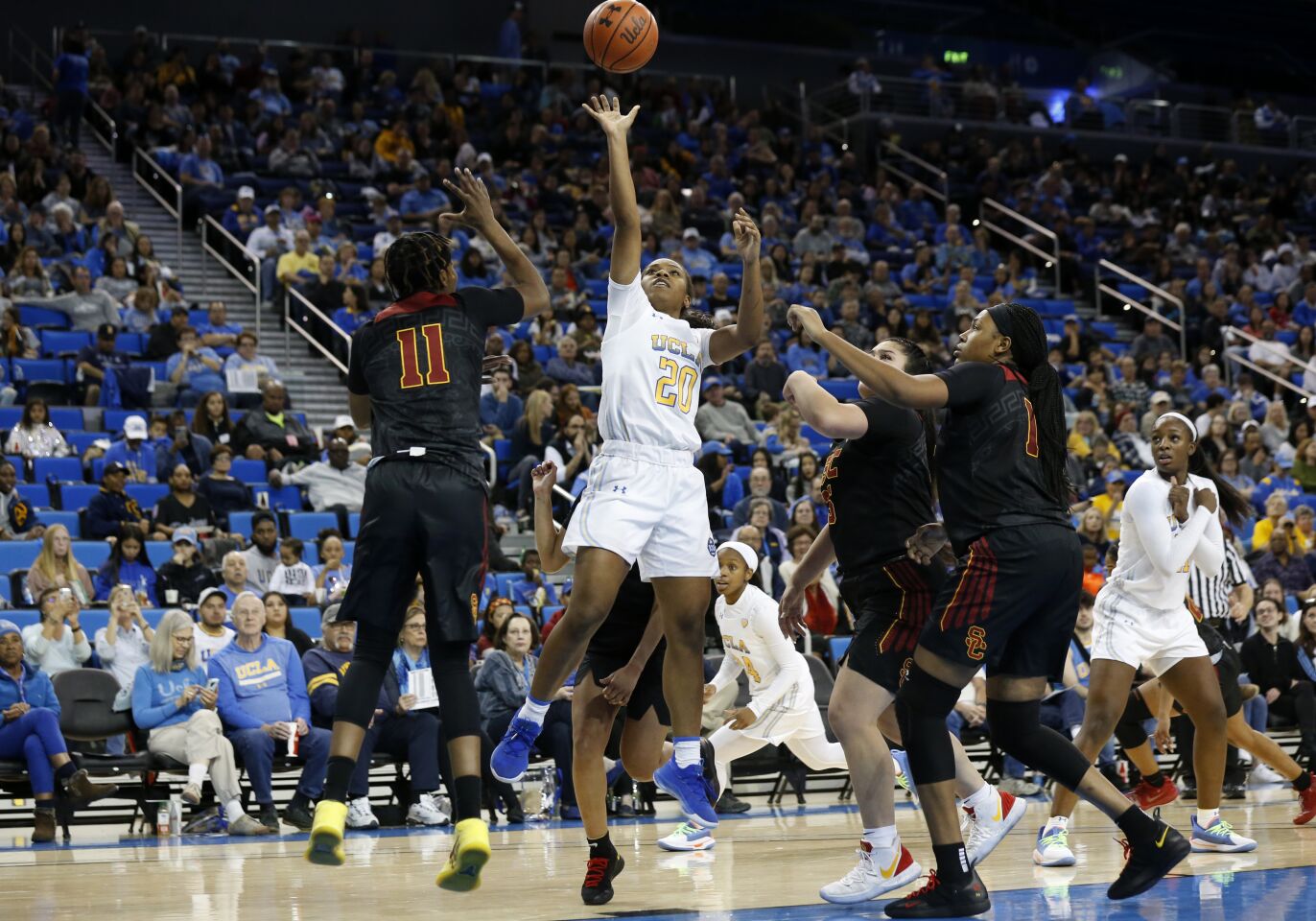 UCLA guard Charisma Osborne scores while being guarded by USC guard Aliyah Jeune (11) and center Angel Jackson (15) during the second half.