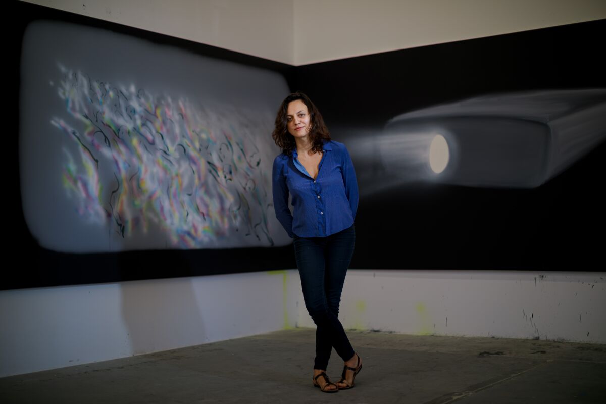 Tala Madani stands before the diptych "Corner Projection (Panic)," 2019, in her Los Angeles studio.