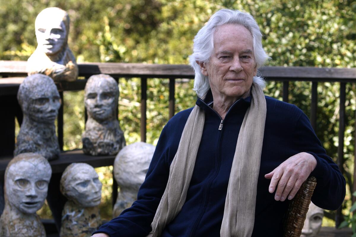 Michael McClure in 2010 on his deck with sculptures by his wife, artist Amy Evans McClure, at their home in Oakland.