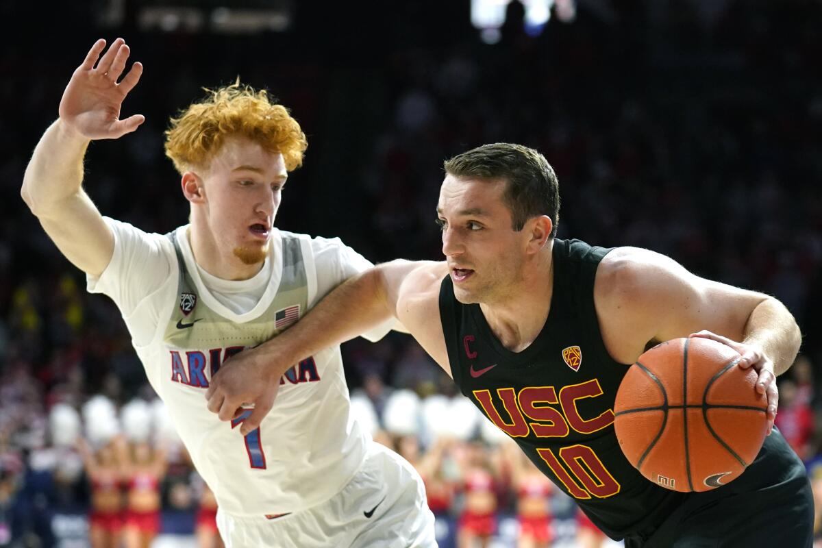 USC guard Quinton Adlesh drives against Arizona guard Nico Mannion during the first half of a game Feb. 6 at McKale Memorial Center. 