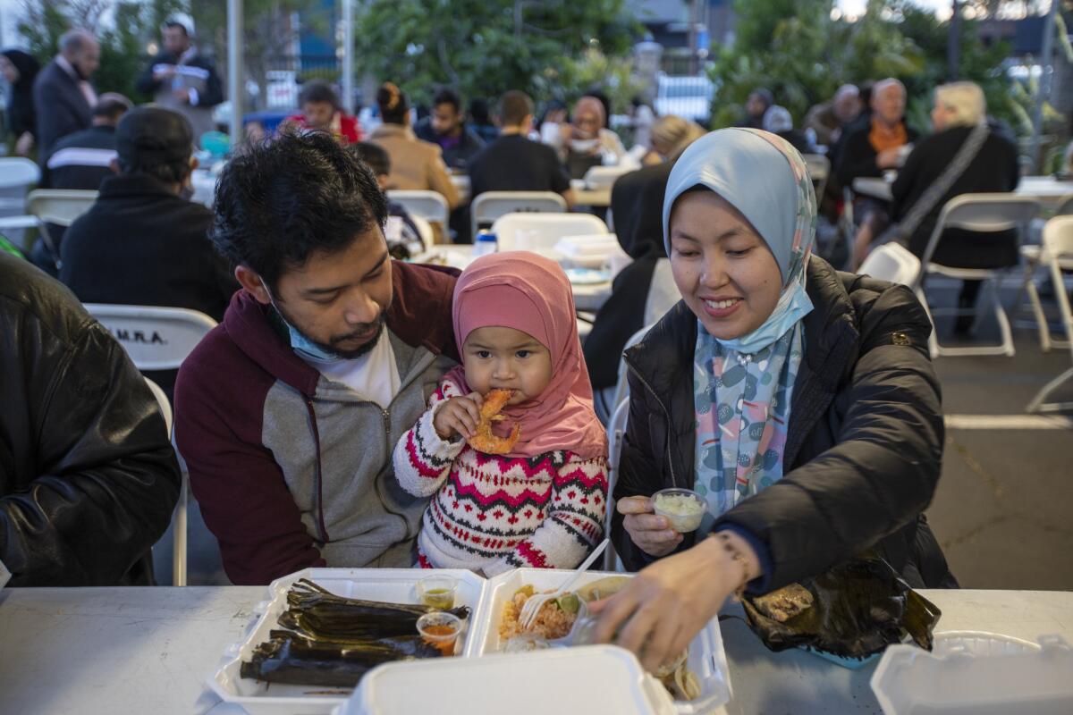 Farith El, left, Farzana Farith, 17 months,  and Mariny Math  enjoy dinner together