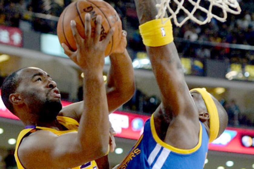 Marcus Landry is blocked by Jermaine O'Neal during a Lakers preseason exhibition against the Golden State Warriors in Beijing. Landry was waived by the team after Friday's 111-106 victory over the Utah Jazz.