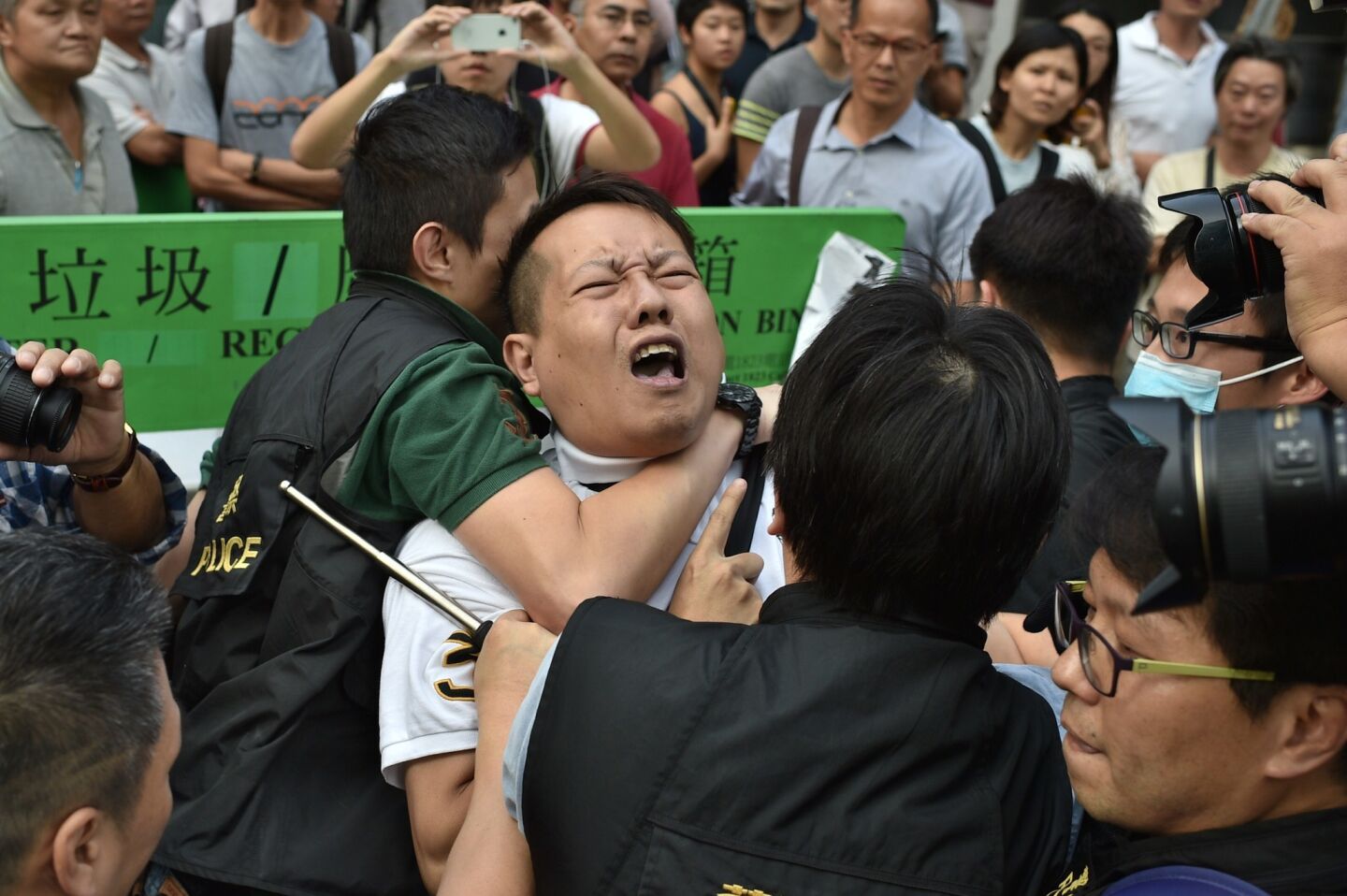 Police officers arrest a protester in the Admiralty district of Hong Kong. Dozens of masked men rushed barricades at Hong Kong's main pro-democracy site, triggering clashes as demonstrators tried to push them back and police struggled to contain the chaos.