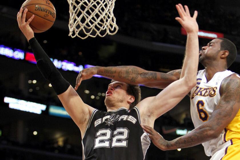 Lakers forward Earl Clark tries to block a shot by Spurs center Tiago Splitter.