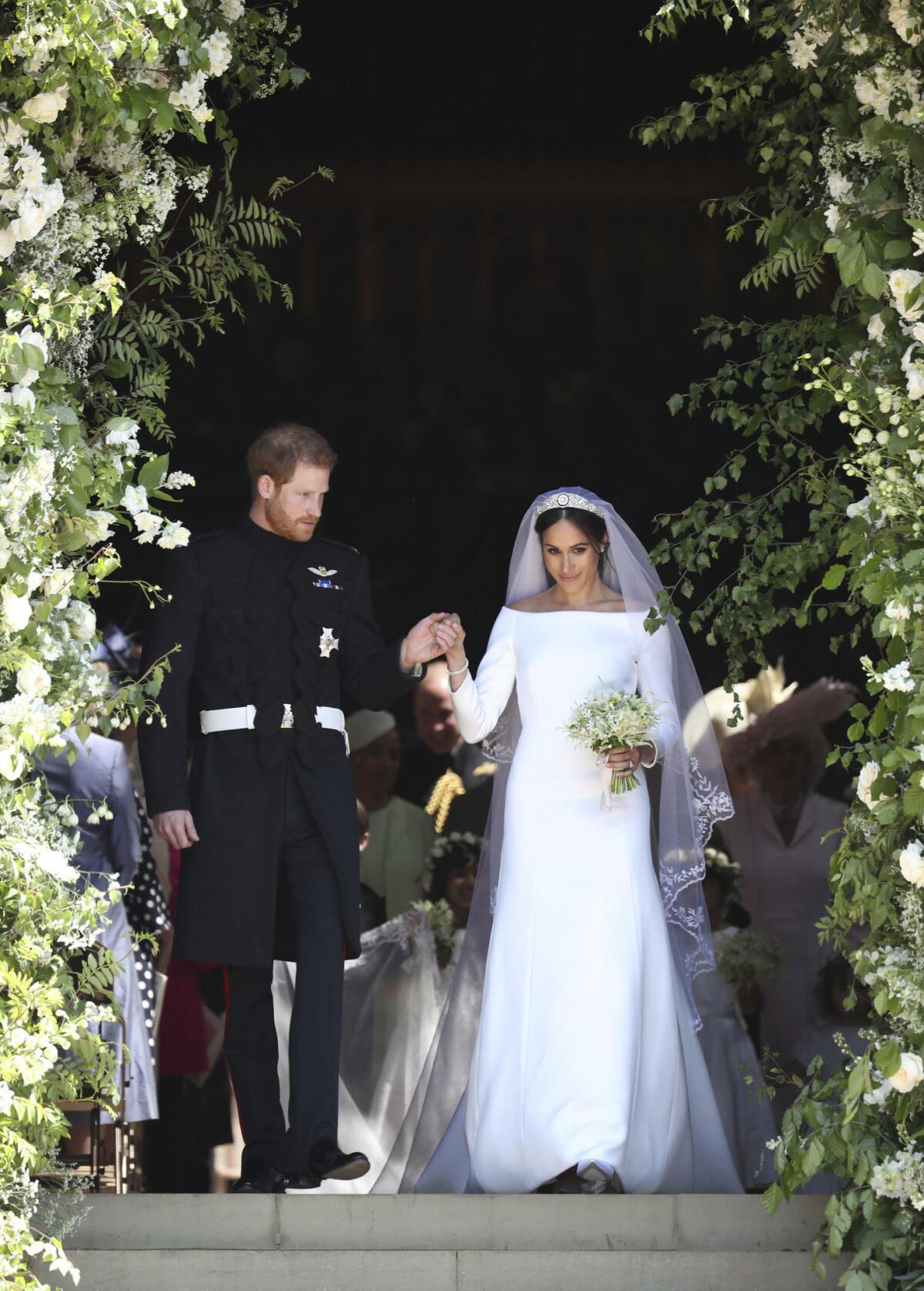 Prince Harry and wife Meghan Markle — the Duke and Duchess of Sussex — exit the steps of St. George's Chapel at Windsor Castle following their wedding Saturday.