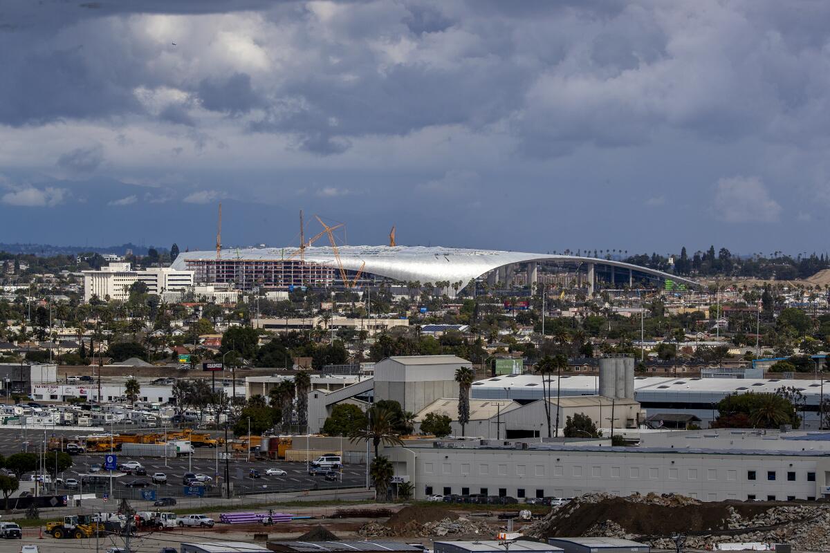 Construction workers work on the SoFi Stadium in Inglewood, where the Rams and Chargers will be playing next season.