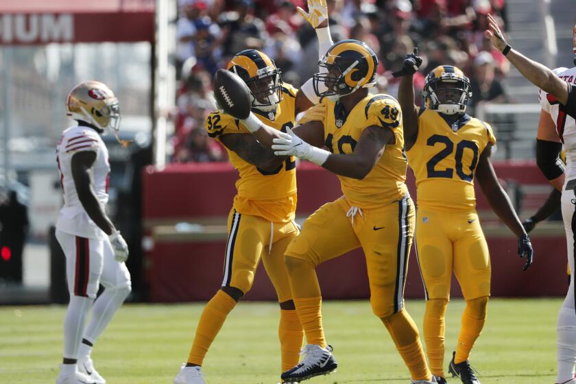 Rams linebacker Trevon Young (49) reacts with teammates Troy Hill (32) and Lamarcus Joyner (20) after intercepting a pass in the first half at Levi's Stadium on Sunday in Santa Clara.