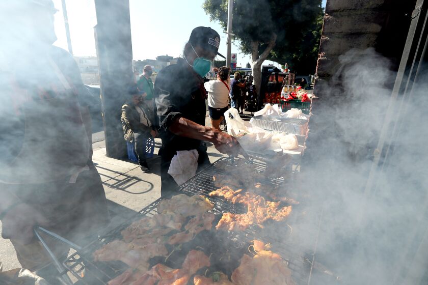 LOS ANGELES, CA. - NOV. 23, 2020. Volunteers grill chicken for a community cookout along Santa Monica Boulevard in East Hollywood on Tuesday, Nov. 24, 2020. Organized by local resident Heleo Leyva with community partners, the regular cookouts provide neighors in need with a hot meal as a break from canned ggoods thhat they might get from local food banks. (Luis Sinco/Los Angeles Times)