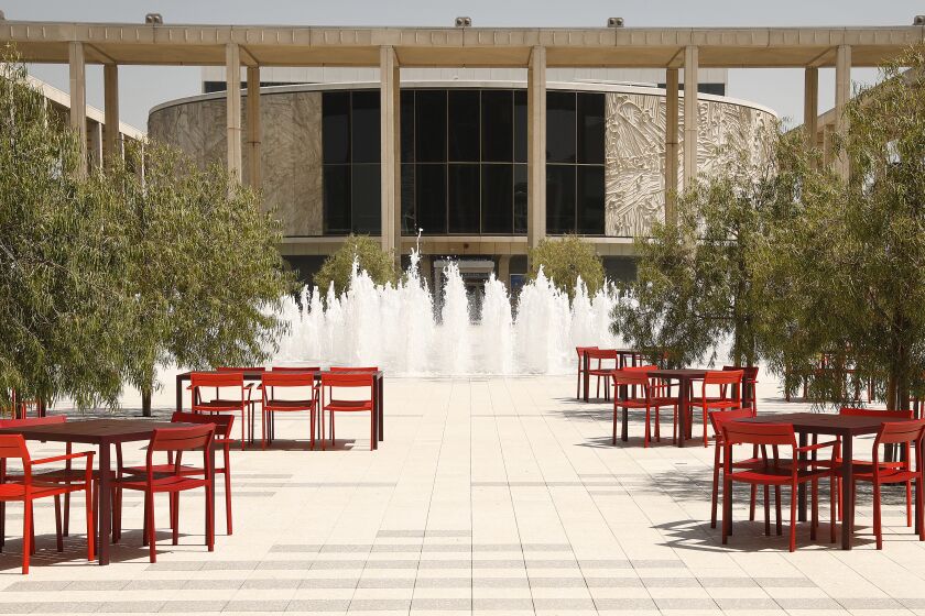 A view of the Music Center plaza shows a fountain and tables in the foreground, with the Mark Taper Forum as backdrop
