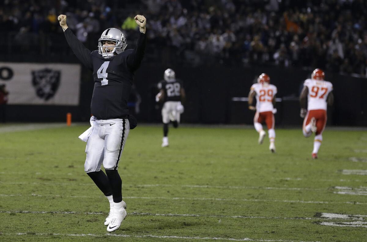 Raiders quarterback Derek Carr raises his hands as running back Latavius Murray sprints for a 90-yard touchdown against the Chiefs in the second quarter.