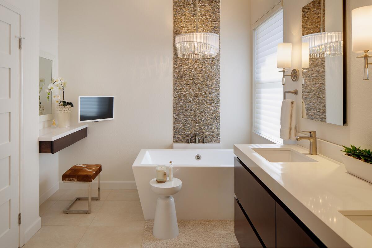 A mother-of-pearl tile accent strip creates a waterfall effect behind the tub in the master bathroom.