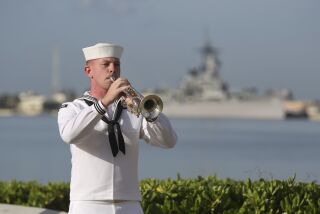 A U.S. Navy sailor plays taps in front of the USS Missouri during a ceremony to mark the anniversary of the attack on Pearl Harbor, Monday, Dec. 7, 2020, in Pearl Harbor, Hawaii. Officials gathered in Pearl Harbor to remember those killed in the 1941 Japanese attack, but public health measures adopted because of the coronavirus pandemic meant no survivors were present. The military broadcast video of the ceremony live online for survivors and members of the public to watch from afar. A moment of silence was held at 7:55 a.m., the same time the attack began 79 years ago. (AP Photo/Caleb Jones, Pool)