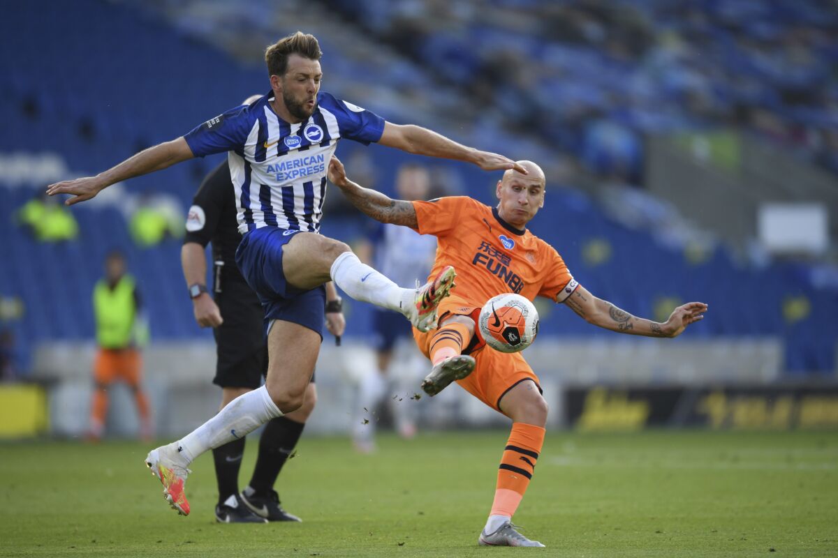 Brighton's Dale Stephens, left, fights for the ball with Newcastle's Jonjo Shelvey during the English Premier League soccer match between Brighton and Newcastle United at the American Express Community Stadium in Brighton, England, Monday, July 20, 2020. (Mike Hewitt/Pool via AP)