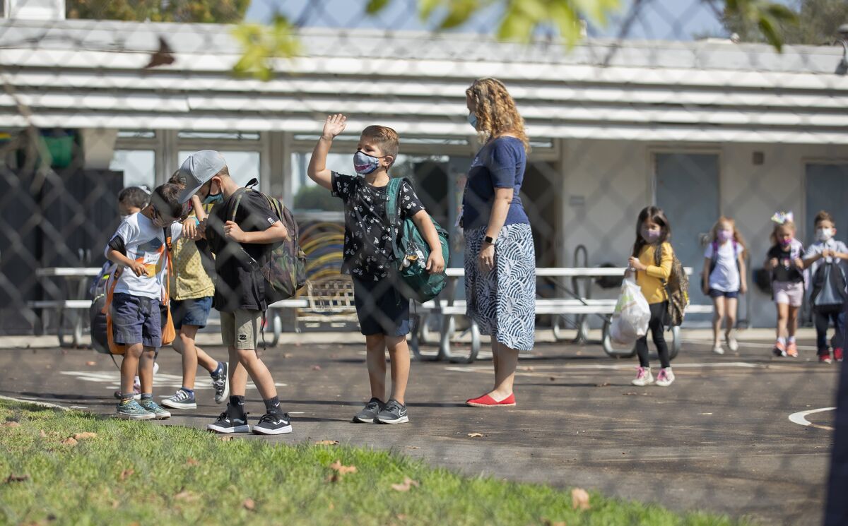 Nash Downing, 6, waves to his mother at Mariners Elementary School in Newport Beach.