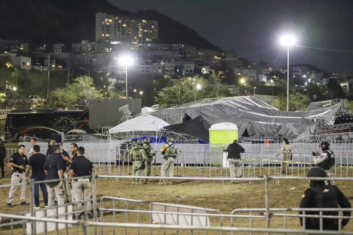 Security forces stand around a stage that collapsed 