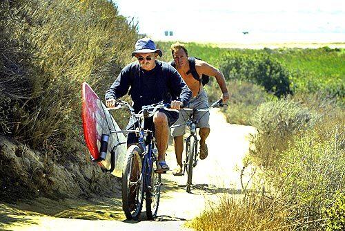 THE BEATEN BATH: For nearly 50 years, photographer Leo Hetzel, foreground, has been escaping to ride the waves at Trestles.