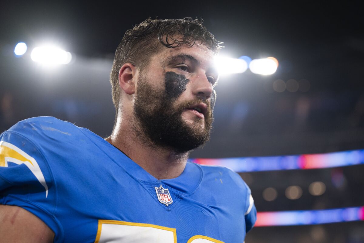 Chargers defensive end Morgan Fox with his helmet off as he walks off the football field.