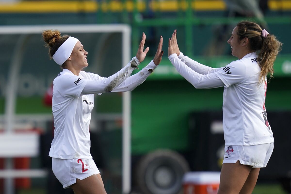 Washington Spirit's Trinity Rodman, left, is congratulated by teammate Sam Staab after scoring against the OL Reign in the first half in the semifinals of the NWSL soccer playoffs Sunday, Nov. 14, 2021, in Tacoma, Wash. (AP Photo/Elaine Thompson)