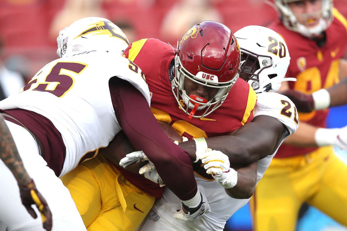 USC running back Markese Stepp is tackled by Arizona State's Cam Phillips and Darien Butler.