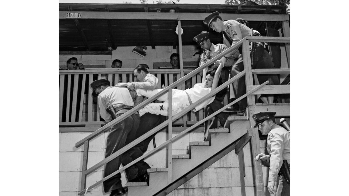 May 8, 1959: Aurora Vargas is carried by Los Angeles County sheriff's deputies during eviction from a house in Chavez Ravine. The photo was taken by Los Angeles Mirror-News photographer Hugh Arnott.