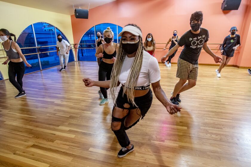 Dance instructor Ebonee Arielle leads masked students in a pandemic hip hop class at 3rd Street Dance Studio in Los Angeles.