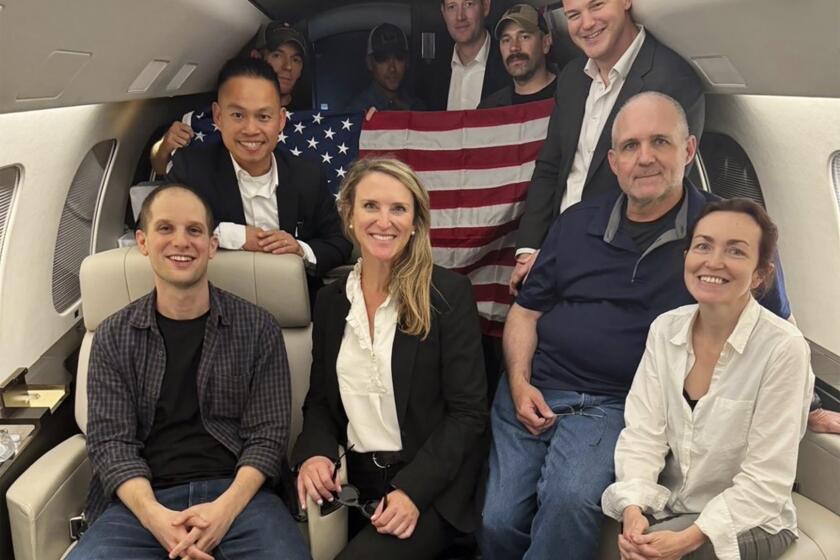 Evan Gershkovich, left, Alsu Kurmasheva, right, and Paul Whelan, second from right, and others aboard a plane, 