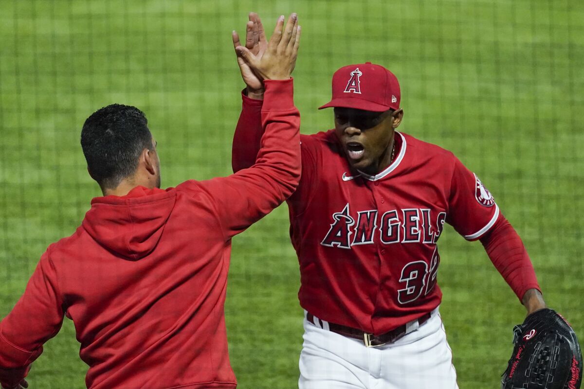 Angels closer Raisel Iglesias celebrates after escaping a bases-loaded jam in the eighth. (AP Photo/Ashley Landis)