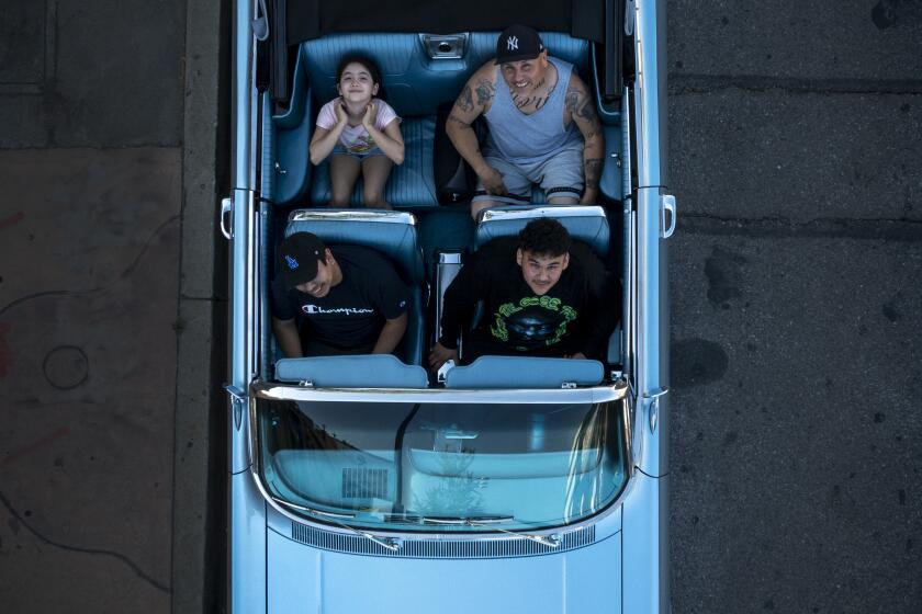Van Nuys, CA - April 17: Mario Garcia II, seated in driver seat, Alexis Alejandre, 18, passenger, Mario Garcia and Karla Ramirez, 8, sit in their 1963 Chevrolet Impala Super Sport as they watch cruisers ride by during the Van Nuys Cruise Night on Van Nuys Blvd. in Van Nuys. People watch classic cars parade down Van Nuys Blvd. during the monthly Van Nuys Cruise Night Van Nuys Blvd. on Saturday, April 17, 2021 in Van Nuys, CA. Cruising is back in a major way in Southern California. The distinctly local custom of leisure drives on urban boulevards in elegant or souped-up vehicles has blossomed during the pandemic, reaching heights of the practice not seen since the heydays of the 1980s and the subsequent crackdown. Car club leaders say they are responsible participants in their community, and lead fundraising drives for kids, relief, and other causes. But neighbors of areas where cruises take place say they feel under siege by the hundreds of vehicles and people who gather, locking down their streets in traffic, and leading to violence or threats. They say their complaints to police and City Hall go unheeded. The scene has also evolved to include so-called "boogies," where a sound system is set up and any parking lot becomes an outdoor dance party. It is parts Chicano vintage culture revival, in the dress and style of the women and men who gather, and part rejection of coronavirus protocols that require social distancing and masks. The scene continues despite the intense toll the pandemic has taken on SoCal Latinos, and some argue such parties and gatherings are super-spreader events. (Allen J. Schaben / Los Angeles Times)
