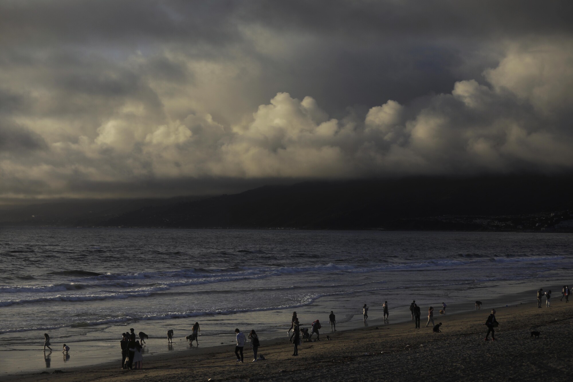 مردم هنگام عبور طوفان در سانتا مونیکا در شب کریسمس موج سواری می کنند.