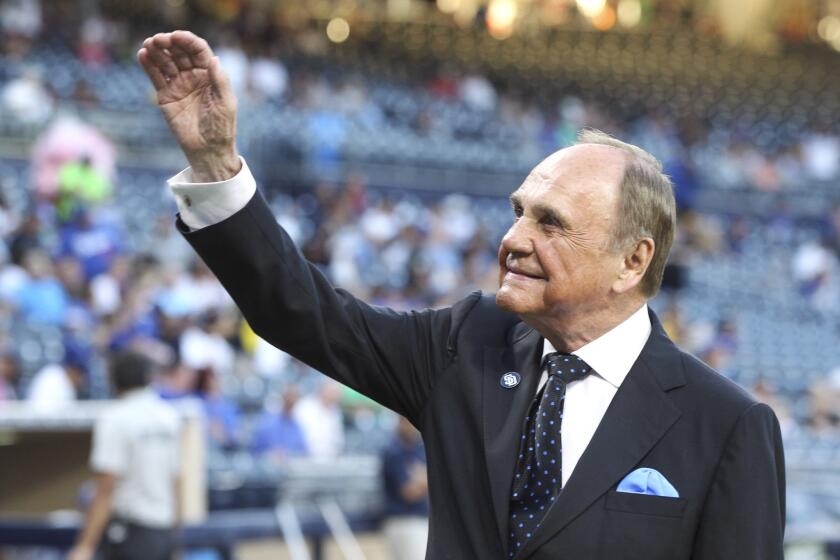 Then-Padres broadcaster Dick Enberg waves to fans during a pregame ceremony honoring the end of his sports broadcasting career at Petco Park in San Diego on Sept. 29, 2016.