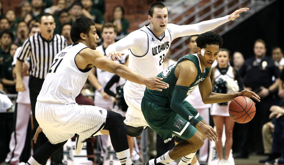 Hawaii's Aaron Valdes dribbles from UC Davis' Josh Fox, left, and Josh Ritchart during the second half of the Big West Conference tournament semifinals on Friday.