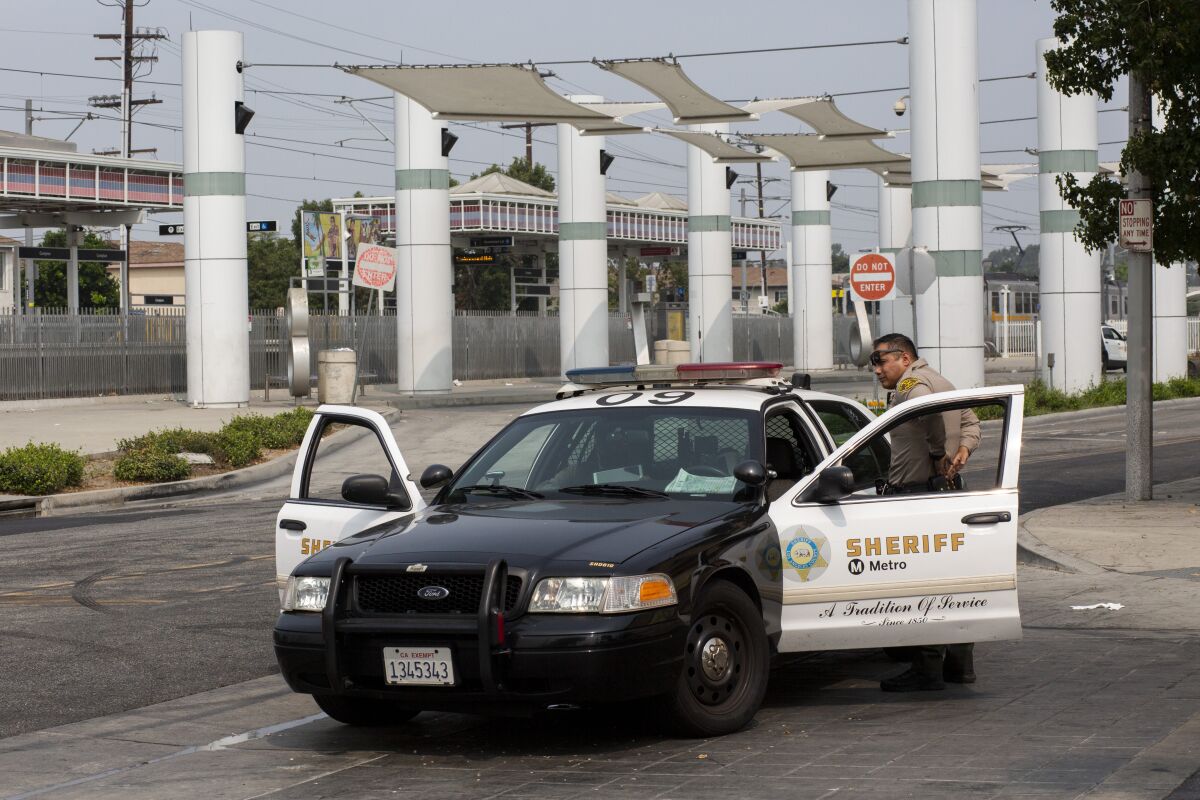 An L.A. County sheriff's deputy patrols near the Compton Metro station in the wake of deputies' shooting.