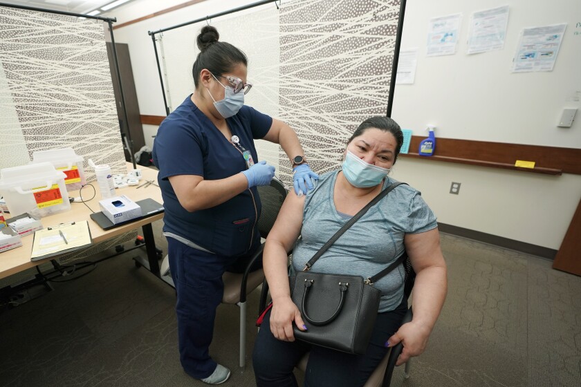 Maria Spindola gets her second shot of the Pfizer COVID-19 vaccine from Cecilia Valdovinos.