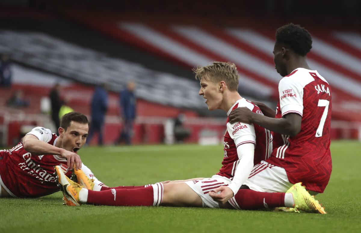 Arsenal's Martin Odegaard, centre, celebrates after scoring his side's opening goal during the English Premier League soccer match between Arsenal and Tottenham Hotspur at the Emirates stadium in London, England, Sunday, March 14, 2021. (Nick Potts/Pool via AP)