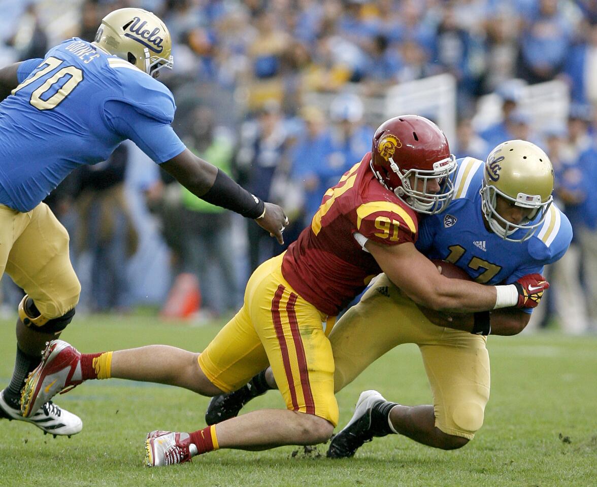 UCLA's QB #17 Brett Hundley is tackled by USC's #91 Morgan Breslin during game vs. USC at the Rose Bowl in Pasadena on Saturday, November 17, 2012.