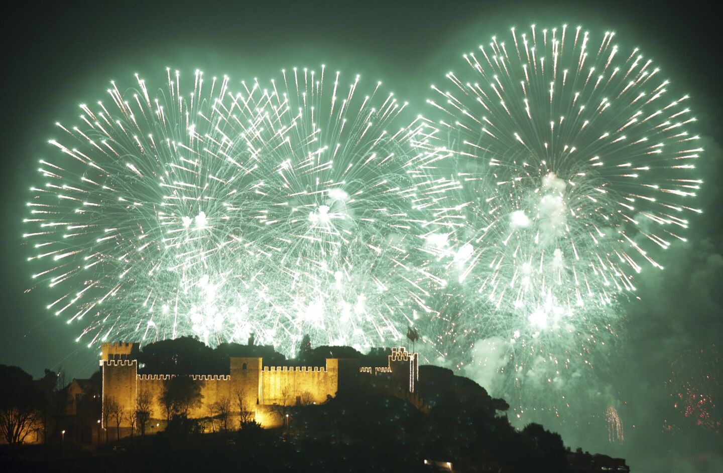 Fireworks light up the sky behind Lisbon's Castle of St. George in the first minutes of Jan. 1, 2019.