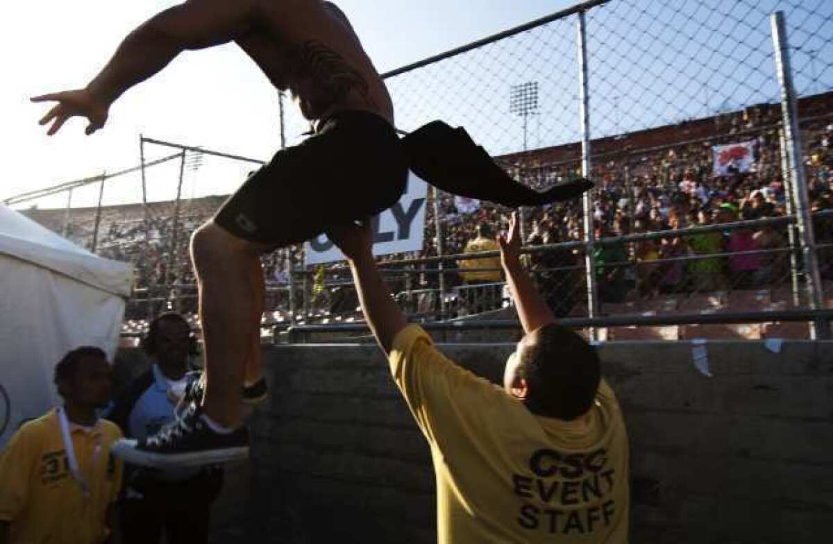 A fan tries to jump a fence at a Coliseum rave, the Electric Daisy Carnival, in June 2010.