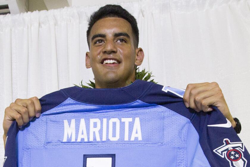 Former Oregon quarterback Marcus Mariota holds up his Tennessee Titans jersey after being picked second overall in the NFL draft on Thursday night.