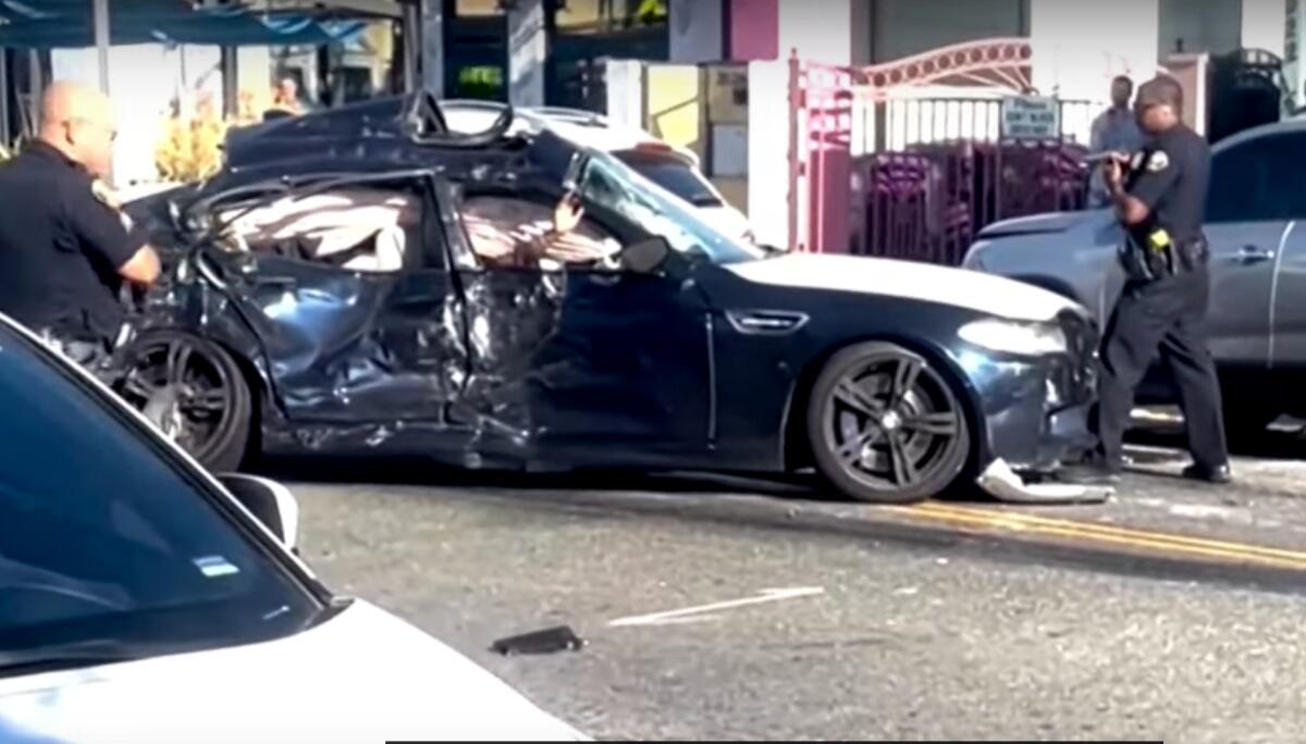 A person waves from a damaged car. 