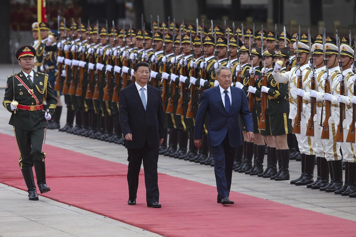 Chinese President Xi Jinping, center, and Kazakhstan President Nursultan Nazarbayev view an honor guard at a welcoming ceremony in Beijing last year.