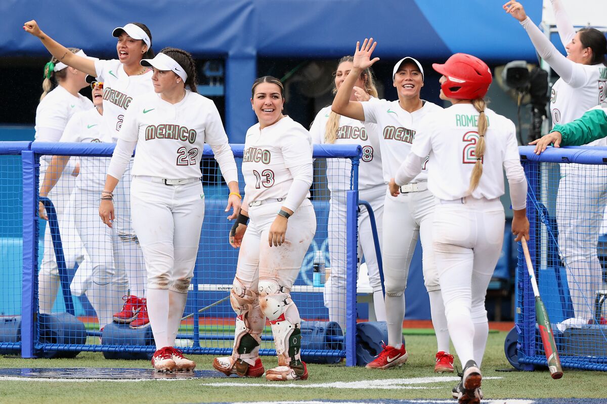 Team Mexico players including Sashel Palacios (13) react after an RBI single during the women's bronze medal softball game.