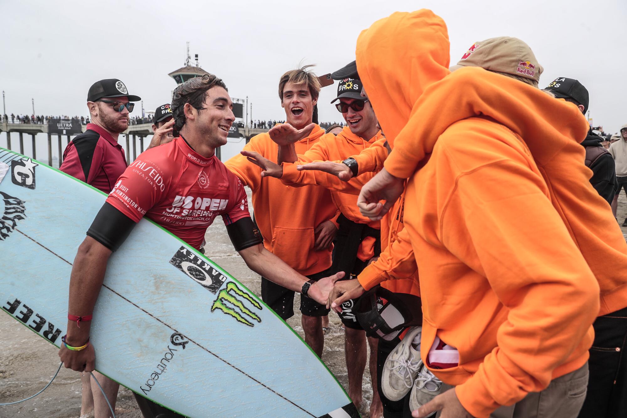 Griffin Colapinto is greeted by friends from San Clemente after he qualified for the finals of the U.S. Open of Surfing