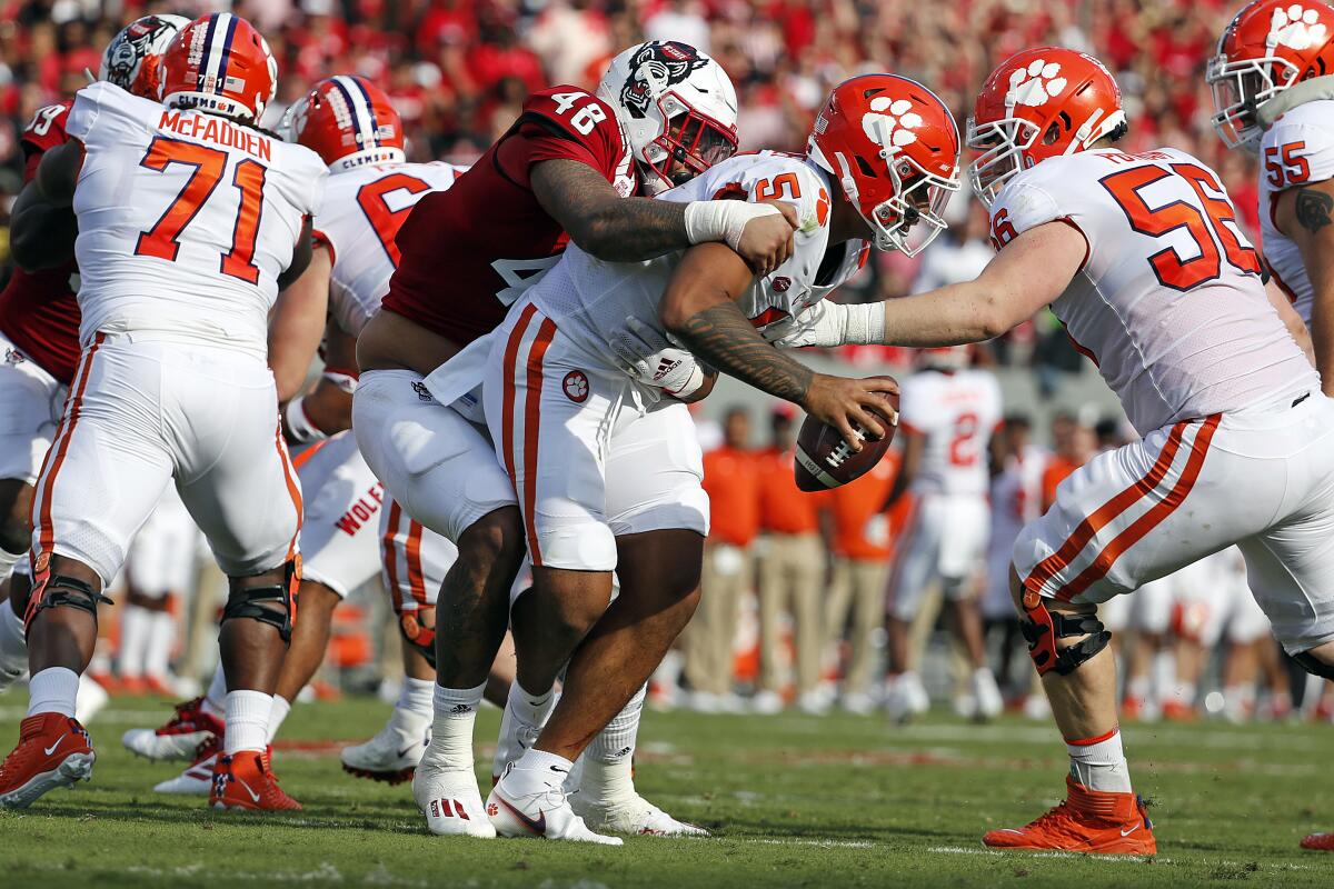 North Carolina State's Cory Durden grabs a hold of Clemson's D.J. Uiagalelei for a sack.