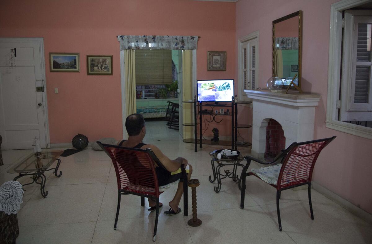 A Havana man sits in his living room at his home with rooms for rent. Home-sharing service Airbnb will allow licensed American travelers to book lodging in Cuba starting Thursday.