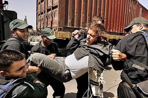 Israeli police struggle with a protester being arrested for blocking the road to the settlement of Neve Dekalim.