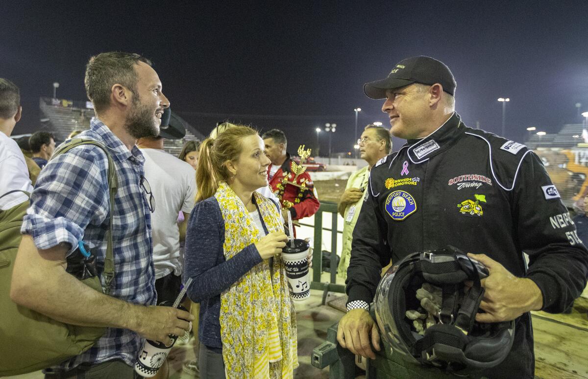 Newport Beach Police Chief Jon Lewis talks with Joe and Jennifer Manzella after Lewis drove against other area police and fire chiefs in the Orange County Fair's Motorhome Madness demolition derby Friday night.