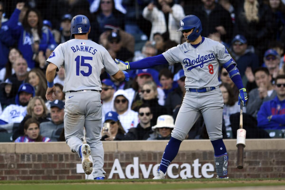 Austin Barnes, left, celebrates with Dodgers teammate Kiké Hernández after scoring on a wild pitch.