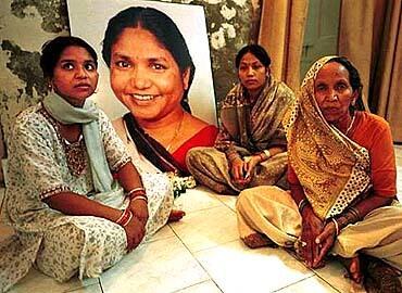 Munni Devi, 27, left, her mother Mulla Devi, 70, right, and sister-in-law Shobho Devi, 32, mourn each day at a livingroom shrine to Devi.