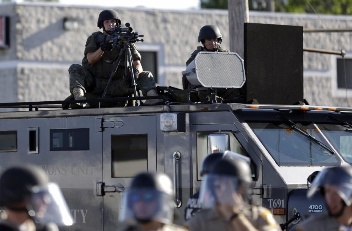 A police tactical team moves in to disperse a group of protesters in Ferguson, Mo., on Aug. 9.